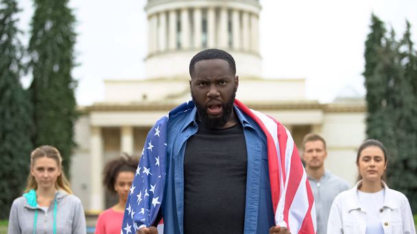 Angry afro-american man wearing USA flag and screaming slogans, racial equality - Φωτογραφία, εικόνα