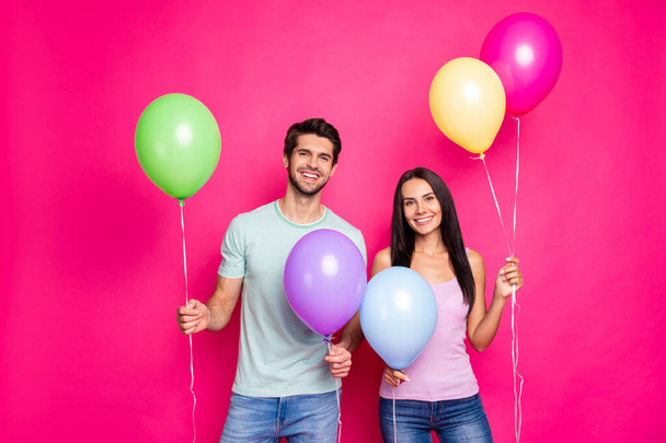 Photo of cute guy and lady holding air balloons in hands came to first summer time party ready chill wear casual outfit isolated pink color background - Foto, immagini