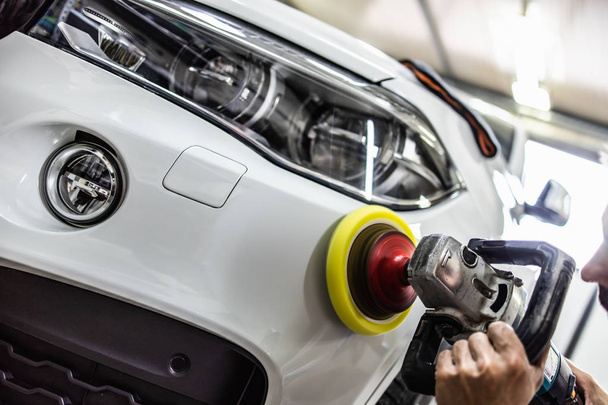 Car detailing - Hands with orbital polisher in auto repair shop. Selective focus. - Zdjęcie, obraz