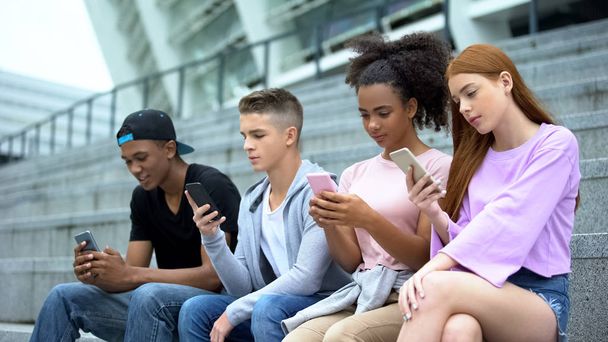 Modern teenagers surfing internet online by smartphone app, gadget addiction - Valokuva, kuva
