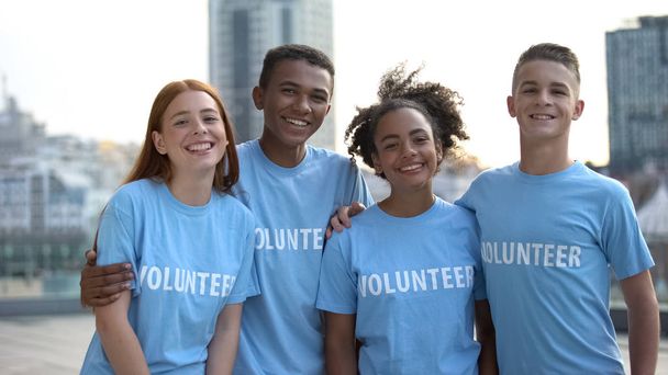 Joyeux jeunes bénévoles t-shirts posant caméra, travail d'équipe sociale, aide
 - Photo, image