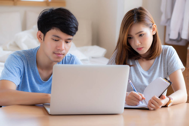Schönes junges asiatisches Paar kalkuliert Spesenfinanzierung mit Schoß - Foto, Bild