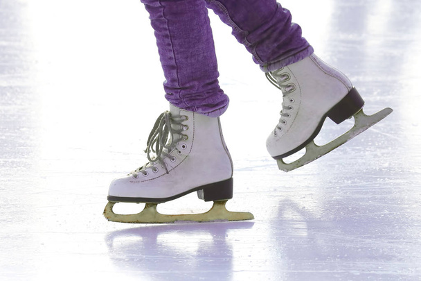 Patas femeninas en patines en una pista de hielo. Deporte y entretenimiento. R
 - Foto, Imagen