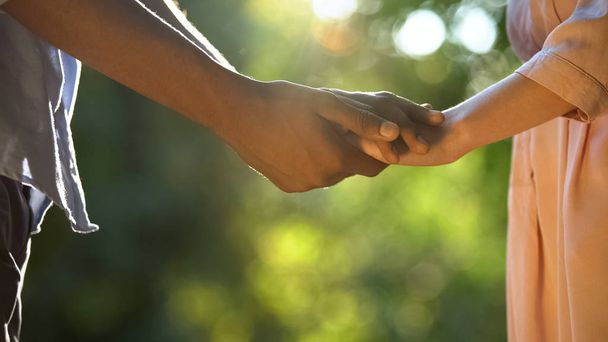 Afro-amerykański chłopak biorąc dziewczyny ręka w Sunny Park, zaufanie Relations - Zdjęcie, obraz
