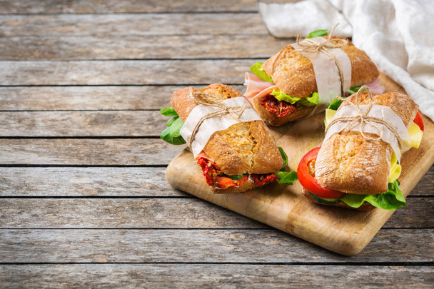 Kanapka ze świeżym chlebem z szynką, sałatą i pomidorami - Zdjęcie, obraz