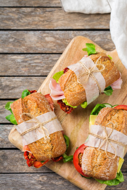Σάντουιτς με φρέσκο ψωμί με ζαμπόν, μαρούλι και ντομάτα - Φωτογραφία, εικόνα
