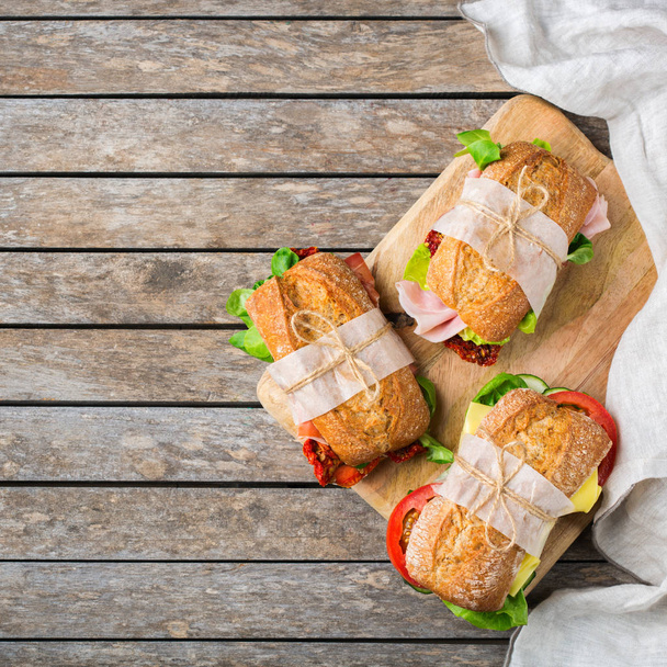 Σάντουιτς με φρέσκο ψωμί με ζαμπόν, μαρούλι και ντομάτα - Φωτογραφία, εικόνα