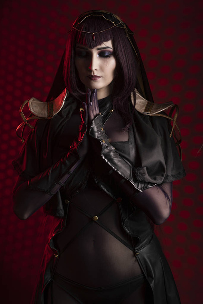 A beautiful busty cosplay girl wearing an erotic leather costume - Фото, изображение