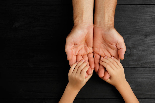 Χέρια ενηλίκων που κρατούν παιδικά χέρια, ιδέα οικογενειακής φροντίδας - Φωτογραφία, εικόνα