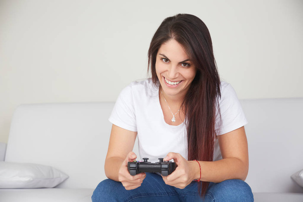 pretty woman play videogames on sofa - Foto, Bild