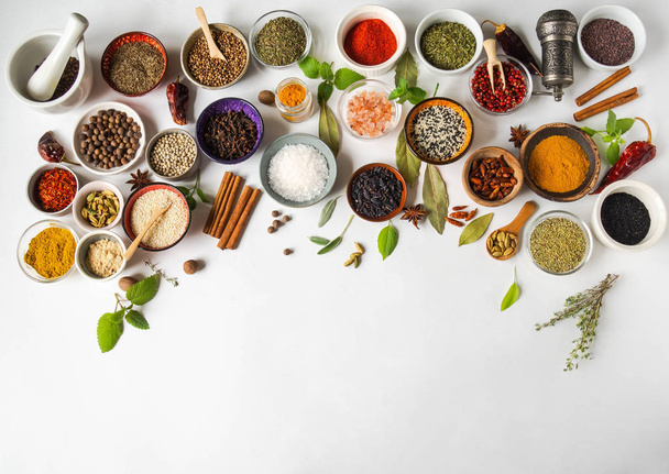 Various dry spices in small bowls and raw herbs flat lay on white background. Top view, copy space - Foto, imagen