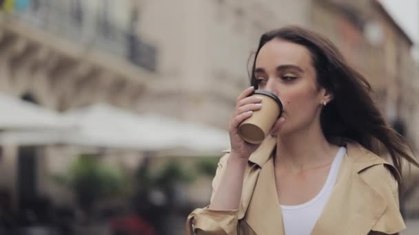 Beautiful Young Girl Holding Paper Cup Drinking Cofee Smiling Walking Relaxed at City Background Close Up. - Video