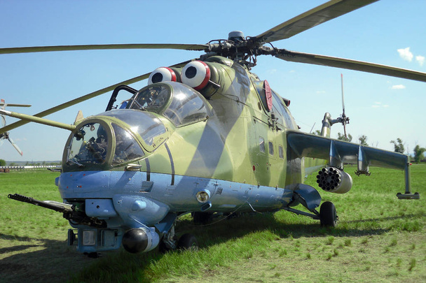 Helicóptero de transporte militar russo mi 24 no aeroporto com vista frontal de grama verde
 - Foto, Imagem