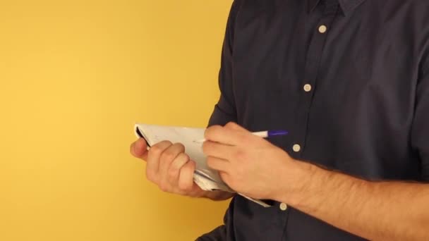 ένας άνθρωπος στέκεται στη μέση της στροφής κρατά σημειώσεις σε ένα σημειωματάριο - Πλάνα, βίντεο
