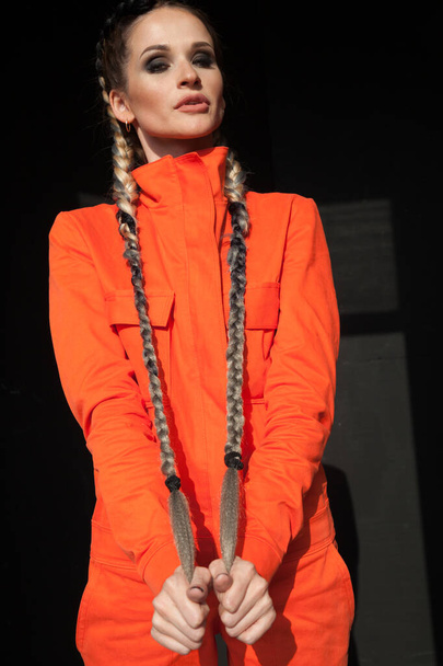 πορτρέτο μιας όμορφης γυναίκας με πορτοκαλί ρούχα εργασίας - Φωτογραφία, εικόνα