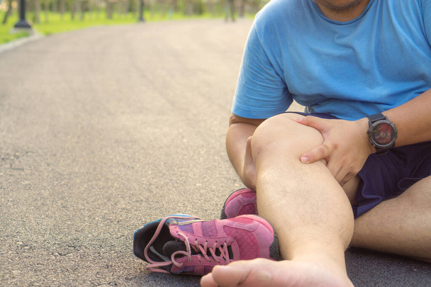Травмы колена. Толстяк держит колено с болями в руках после
 - Фото, изображение