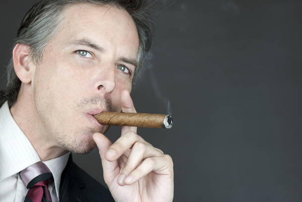 Magabiztos üzletember dohányzik szivart, oldalsó - Fotó, kép