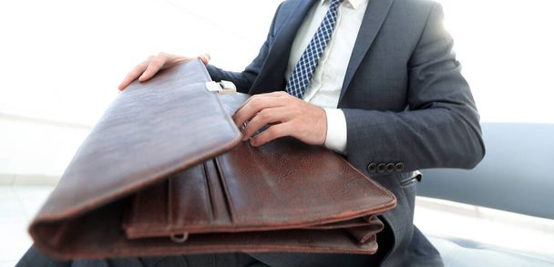 businessmans hand with suitecase in a modern office - Fotografie, Obrázek