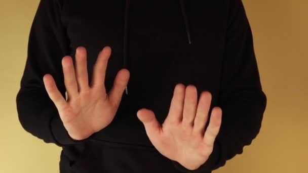 Egy fekete kapucnis férfi sok kézmozdulatot tesz.. - Felvétel, videó