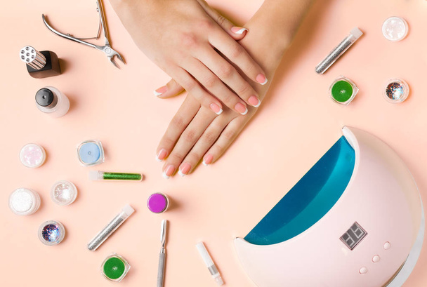 Composition for nail care, female young hands, French manicure, gel polish, lamp for nails and equipment for nail care. Flat lay photo. - Photo, Image