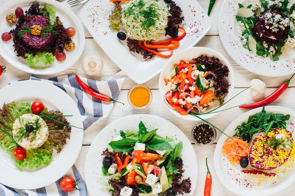 festive banquet table vegetable salads assortment - Foto, afbeelding