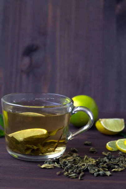 tazza di tè verde con lime fresco sul tavolo di legno scuro
 - Foto, immagini