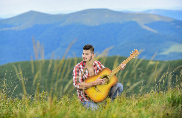 Compose melody. Inspiring environment. Acoustic music. Summer music festival outdoors. Playing music. Sound of freedom. Man with guitar on top of mountain. Inspired musician play rock ballad - Foto, Bild