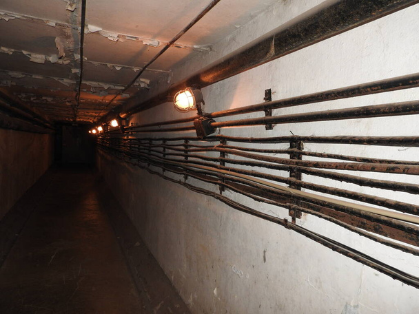 Abandoned prison in underground bunker. Ghost of prisoner. Ex Soviet cold war bomb shelter. Hermetic doors of bunker. Pipes and valves. Low light condition. Bunker of fear and nightmares. - Photo, Image