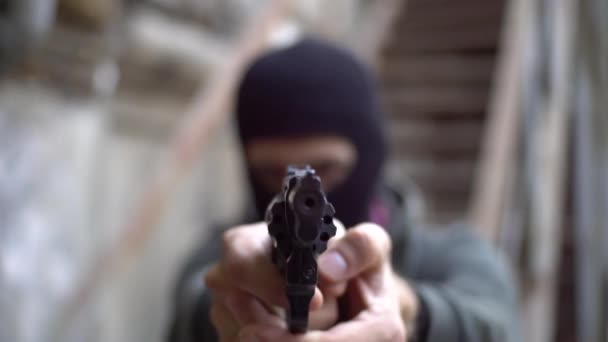 Bandit with black gun , robber on the street, urban abandoned background - Кадри, відео