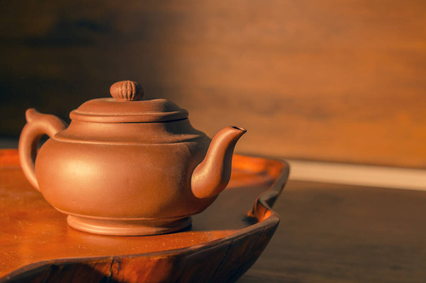 Retro clay Chinese teapot on a brown background - Фото, изображение