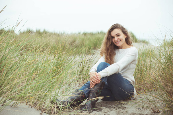 Portrait of pretty young woman posing on the Baltic sea beach in - Fotoğraf, Görsel