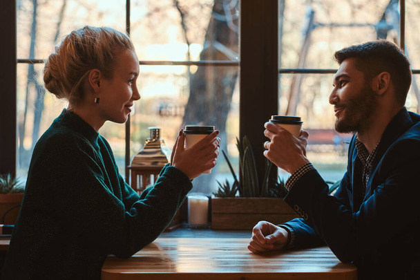 Romantic couple is sitting at cafe at their date - 写真・画像