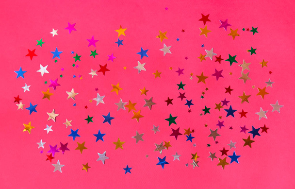  Patrón de colorido confeti brillante en forma de estrellas sobre fondo rosa
.  - Foto, imagen