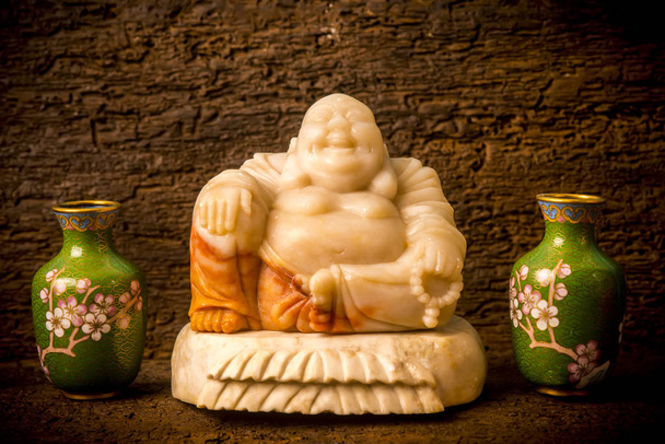 Figura Hotey de Buda de cerámica entre jarrones en estante
 - Foto, imagen