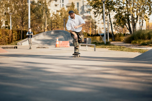 Человек в скейтпарке катается на скейтборде в теплый осенний день
 - Фото, изображение