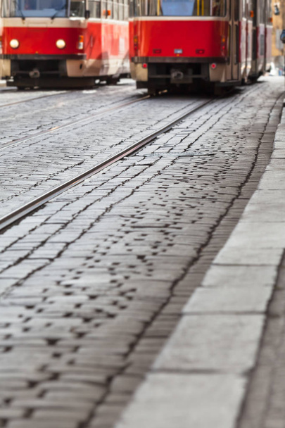 Cobblestone road at city with tram tracks and streetcar traffic detail as background (copy space) - Photo, Image