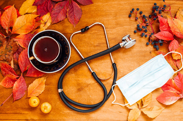 medicina tratamiento frío hojas rojas y amarillas de fondo de madera de otoño
 - Foto, imagen