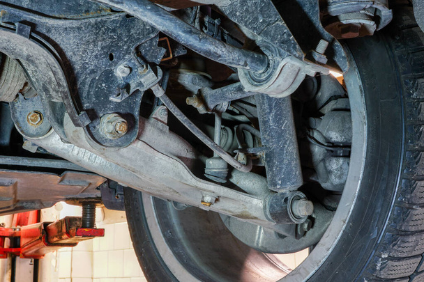 roue de voiture et détail de suspension de l'automobile soulevée à la station-service de réparation
 - Photo, image