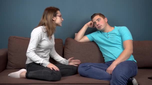 schreit eine junge Frau einen jungen Mann an. ein Mann achtet nicht auf eine Frau. auf der Couch sitzen - Filmmaterial, Video