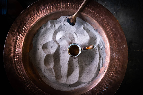 Turkse koffie bereiden in het zand, Arabische stijl koffie bereiden met zand - Foto, afbeelding