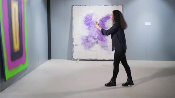 Meisje met mobiel fotograferen in kunstgalerie - Video