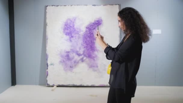 Sanat galerisi ziyaretçisi soyut resmin fotoğrafını çekiyor - Video, Çekim