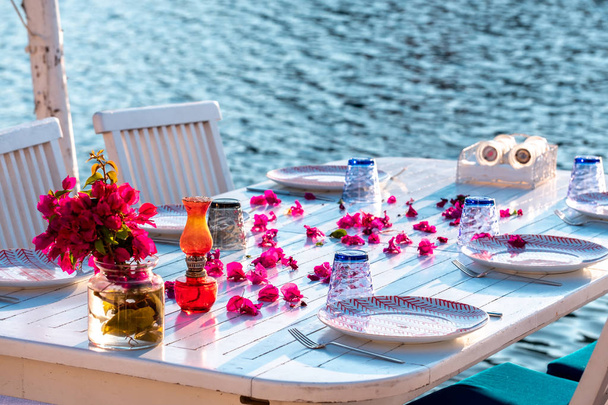 Aegean fish restaurant table in Gumusluk Town, Bodrum, Turkey. Restaurant tables and chairs are in the sea - Photo, Image