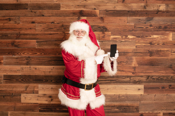 Santa Claus pointing on mobile phone. - Photo, Image