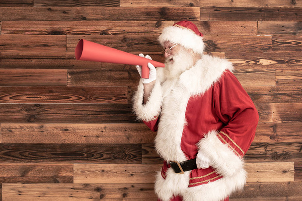 Santa Claus screaming through a huge megaphone. - Fotografie, Obrázek