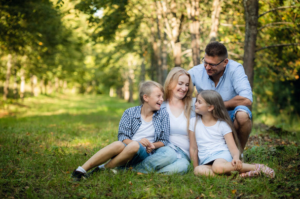 Portrait de famille heureuse de quatre personnes dans un parc d'été verdoyant
 - Photo, image