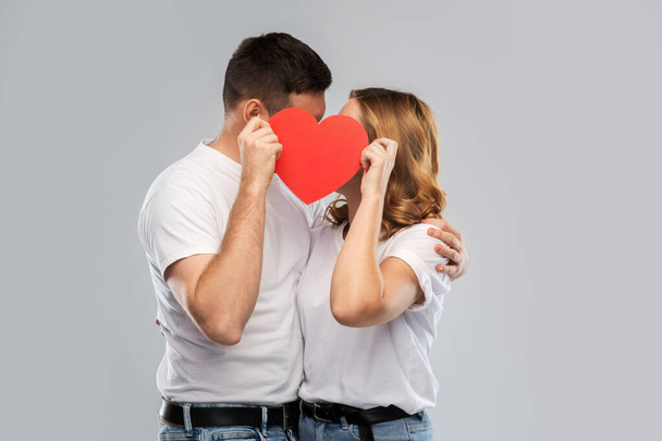 smiling couple kissing behind big red heart - Foto, Imagem