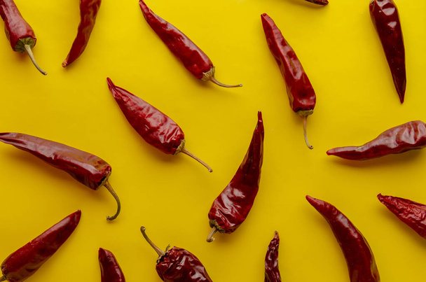 Red chilli peppers on yellow background. Pattern. - Valokuva, kuva