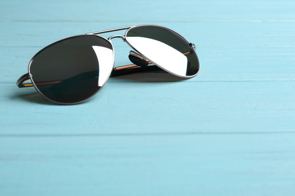 Stylish sunglasses on blue wooden background. Fashionable accessory - Foto, Imagem
