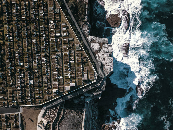 Pohled z ptačí perspektivy na vlny narážející na útesy a hřbitov, Bondi to Coogee Beach Coastal Walk, Sydney, Austrálie. - Fotografie, Obrázek